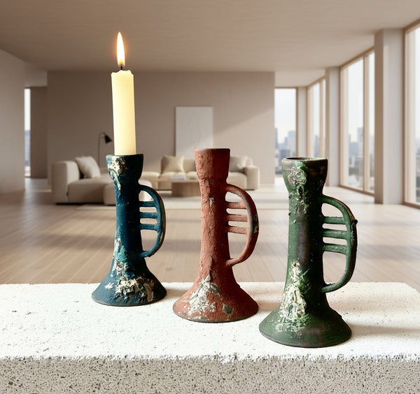 Three ceramic candle holders on a white surface with a neutral background