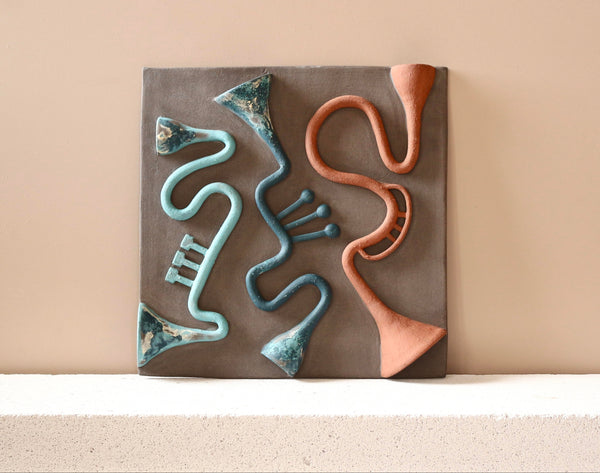 Decorative wall art with abstract designs on a beige background